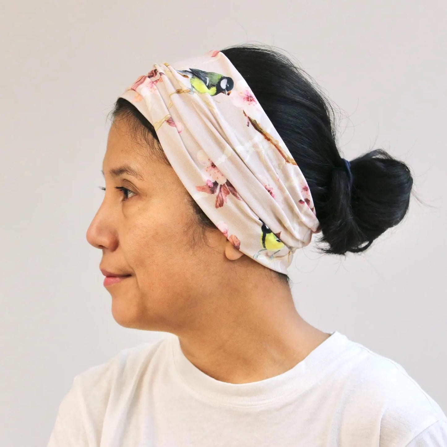 Person wearing a floral headband with a white background