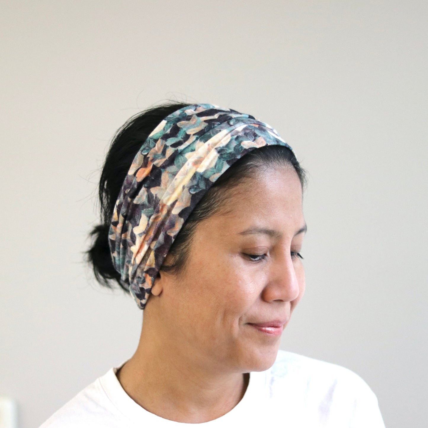 Woman wearing a patterned headband against a plain background