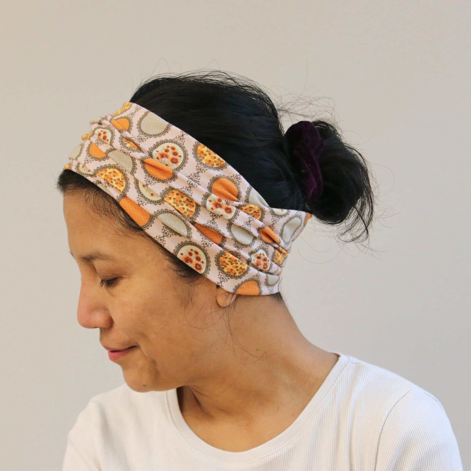 Person wearing a patterned headband with a neutral background