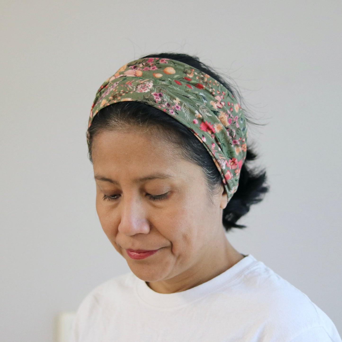 Woman wearing a patterned headband against a plain background