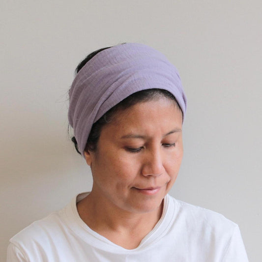 Woman wearing a purple headband against a plain background