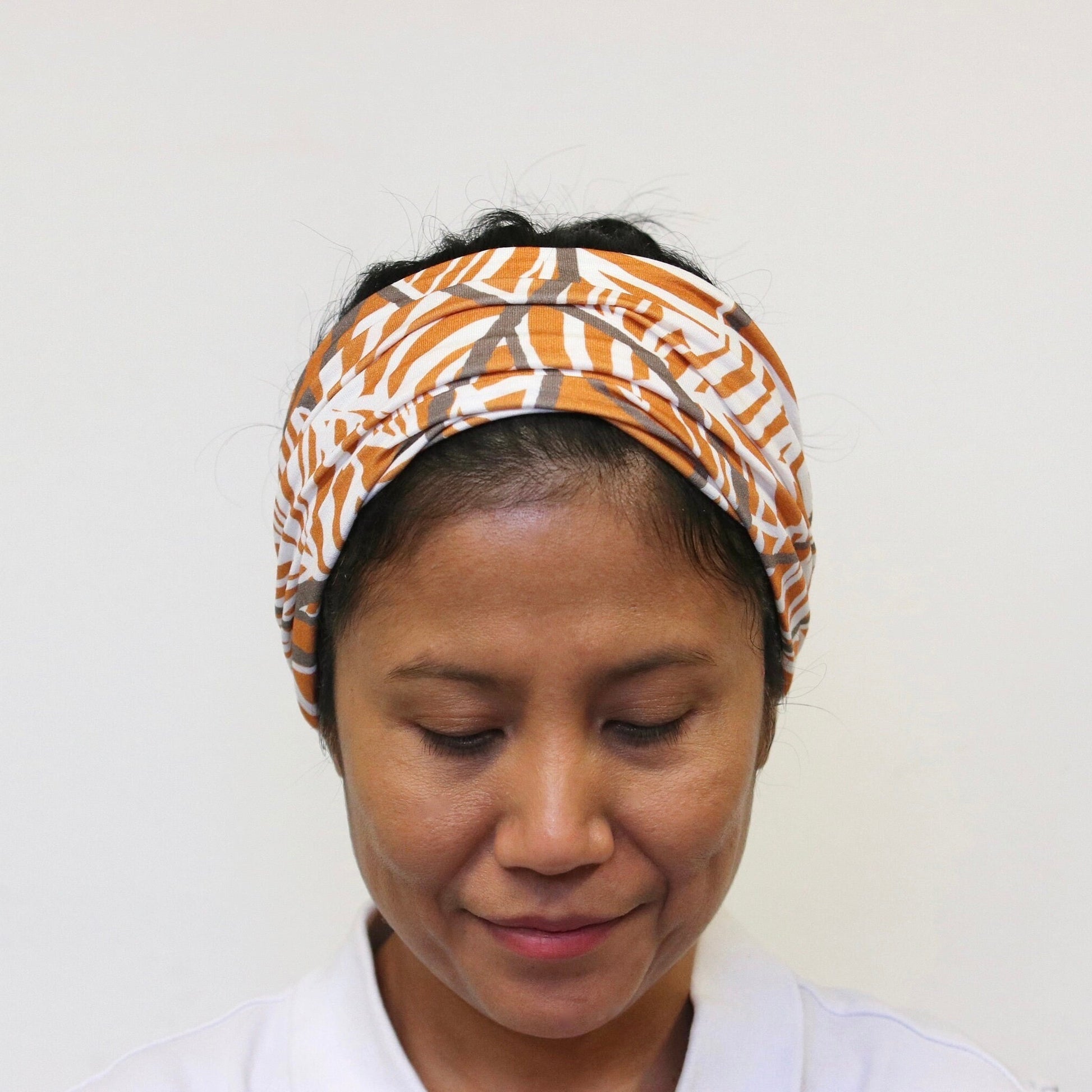 Person wearing a patterned headband against a plain background