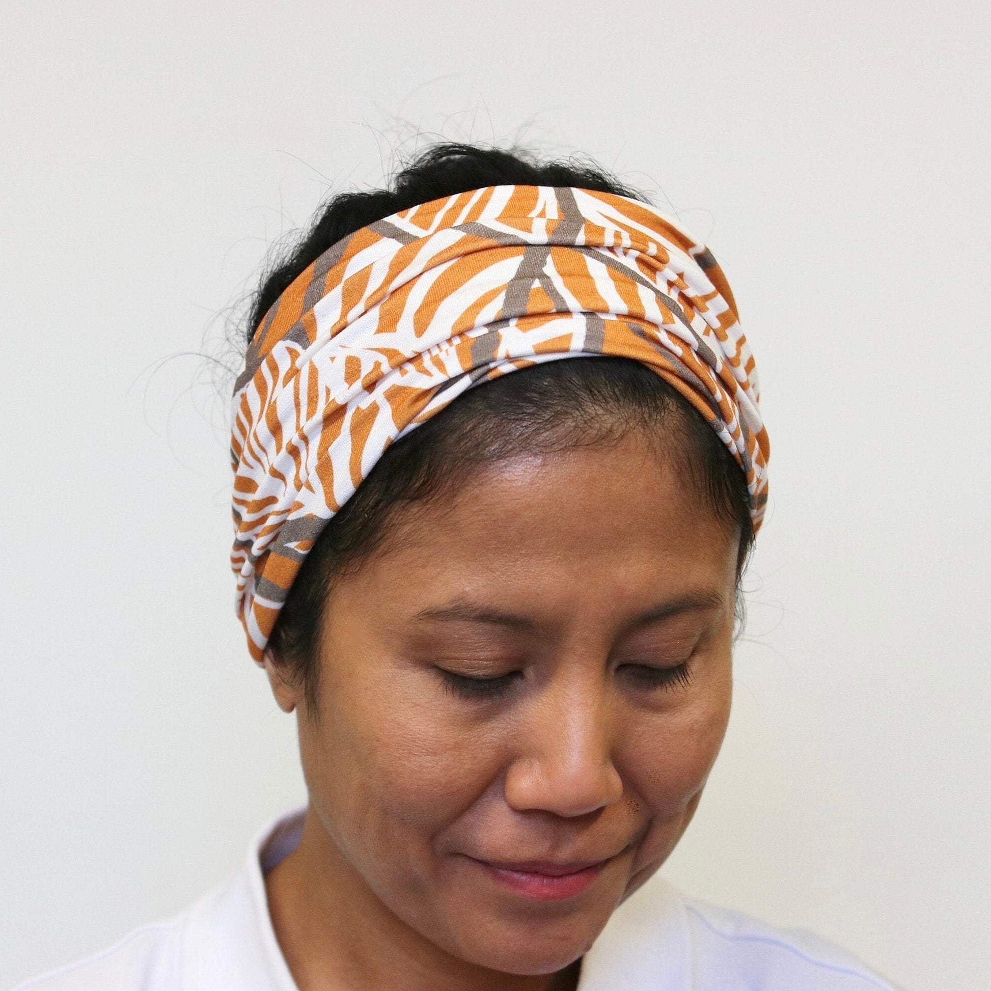 Person wearing a patterned headband against a plain background