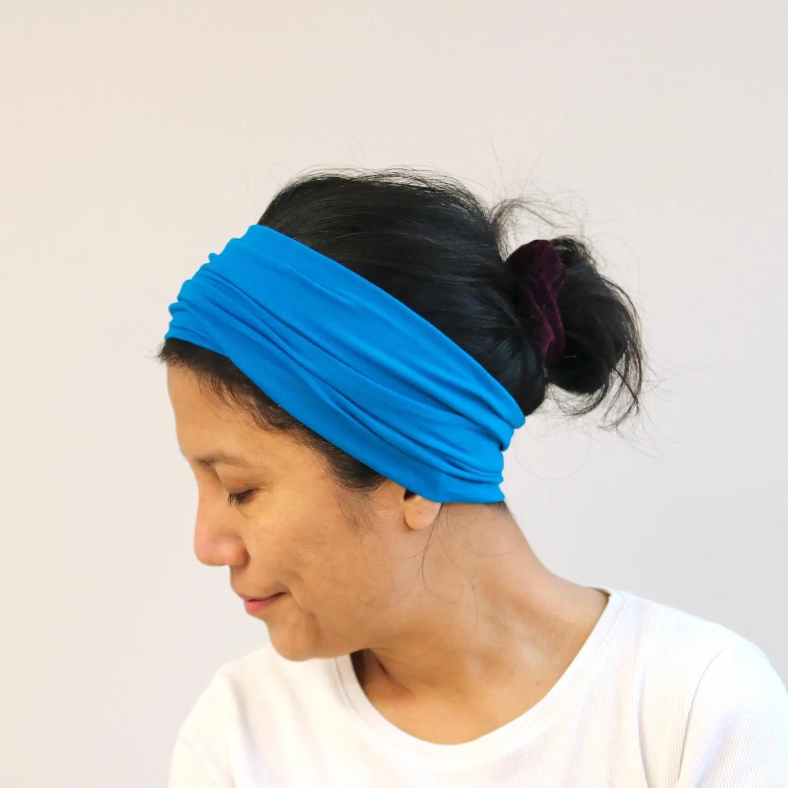 Person wearing a blue headband against a plain background