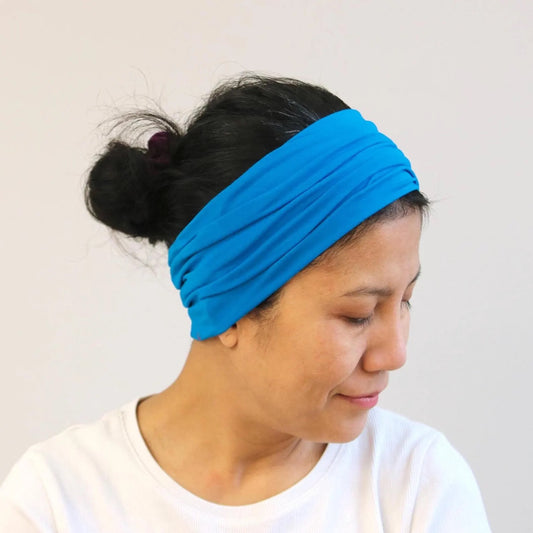 Person wearing a blue headband against a plain background