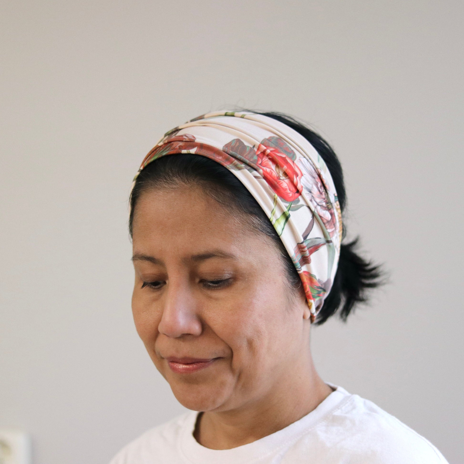 Woman wearing a patterned headband against a plain background