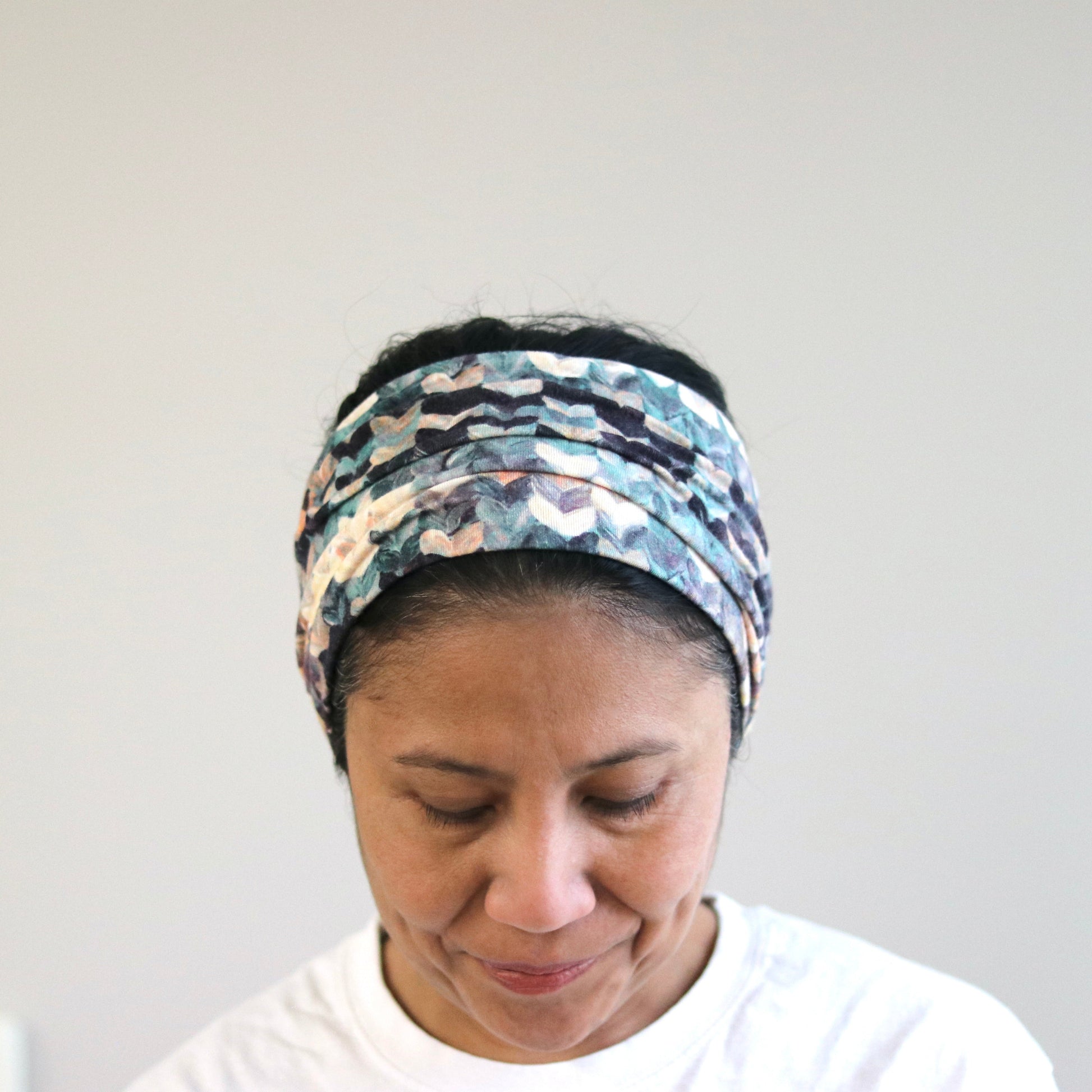 Person wearing a patterned headband against a plain background