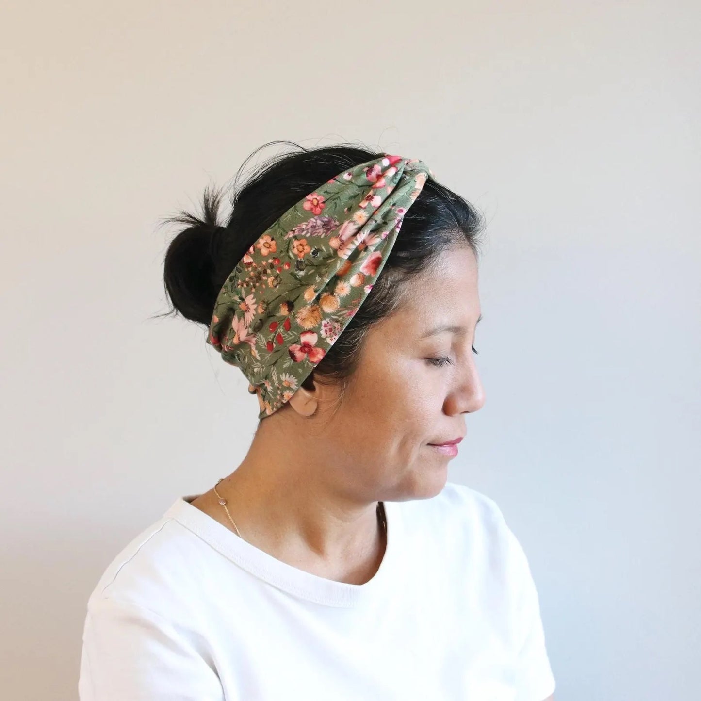 Woman wearing a floral headband with a plain background