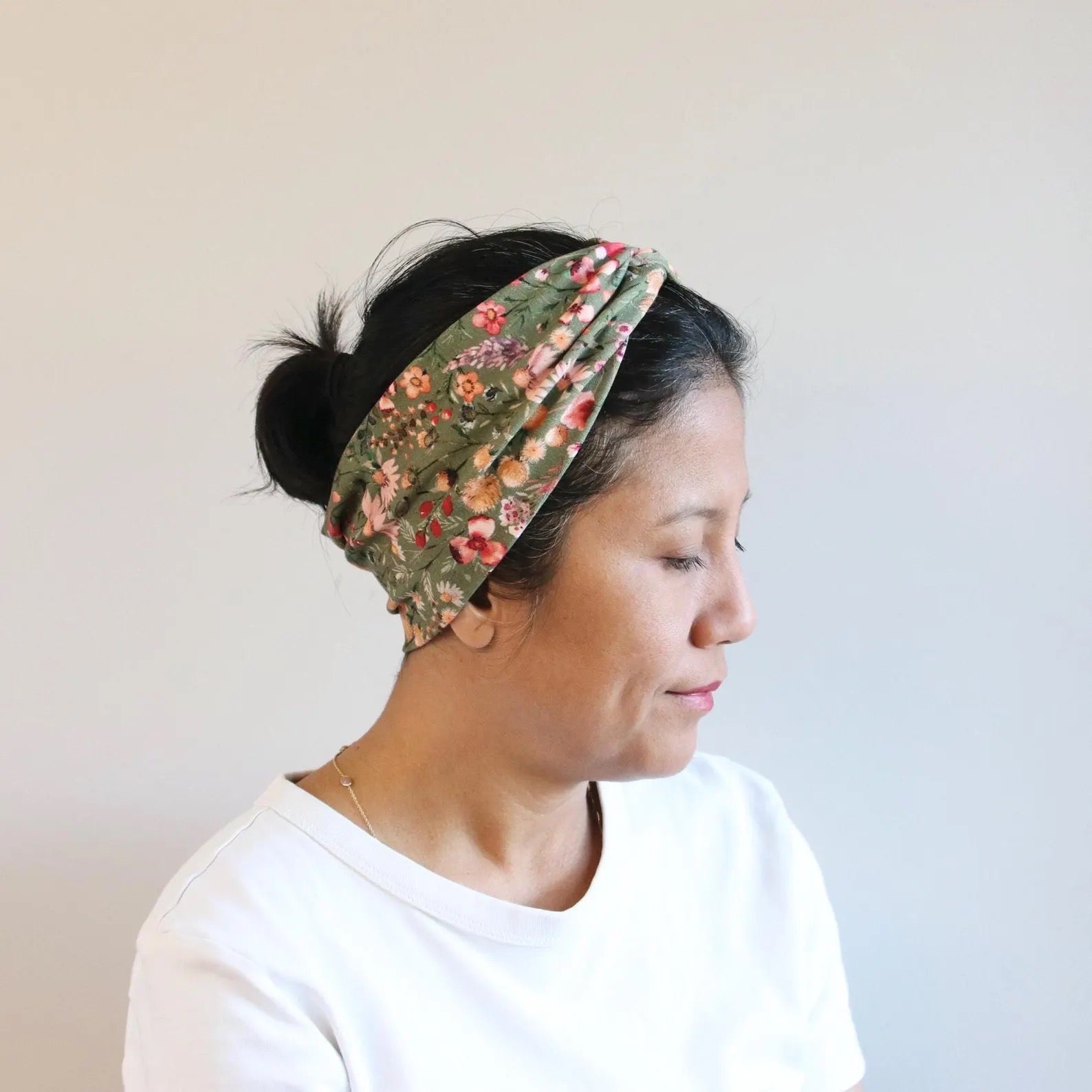 Woman wearing a floral headband with a plain background
