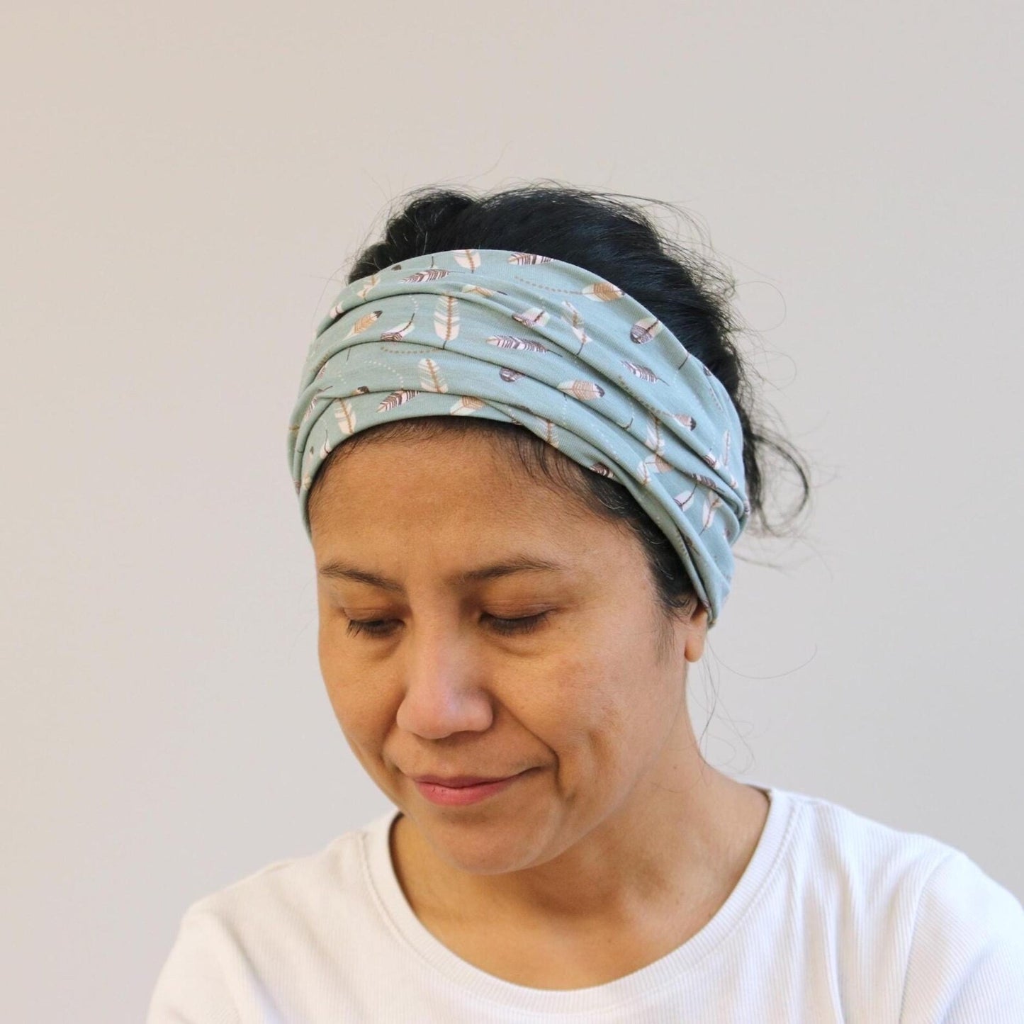Woman wearing a patterned headband against a plain background