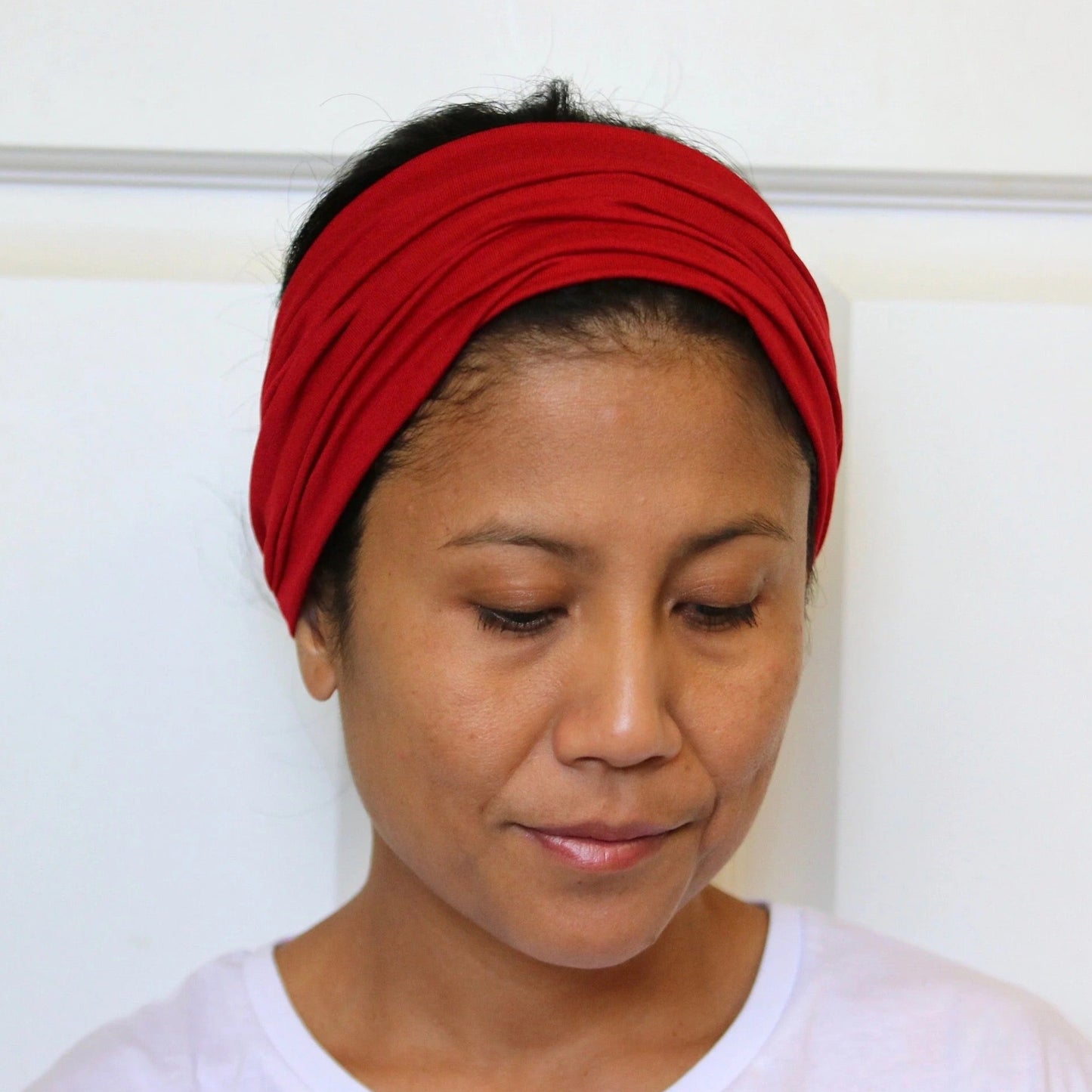 Person wearing a red headband against a white background