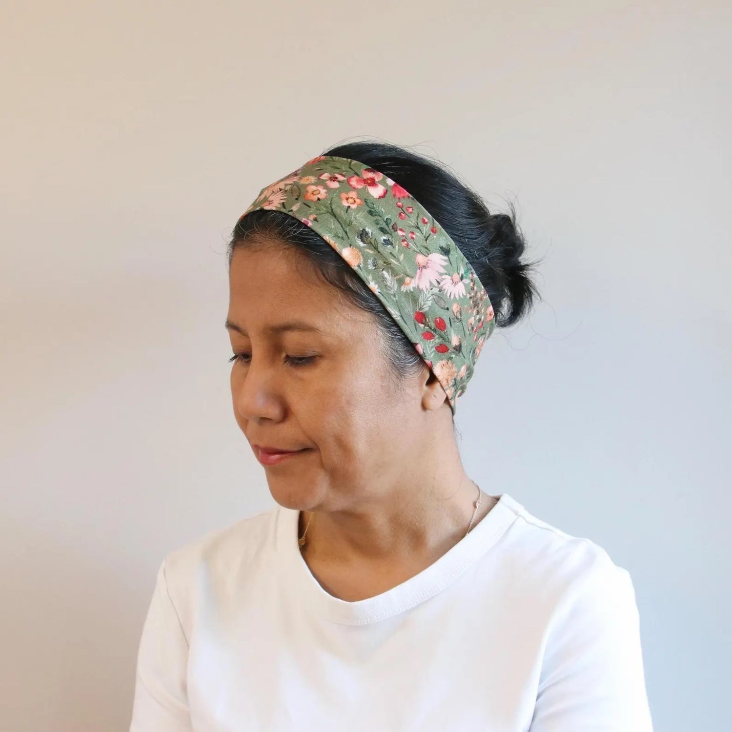 Woman wearing a floral headband with a plain background
