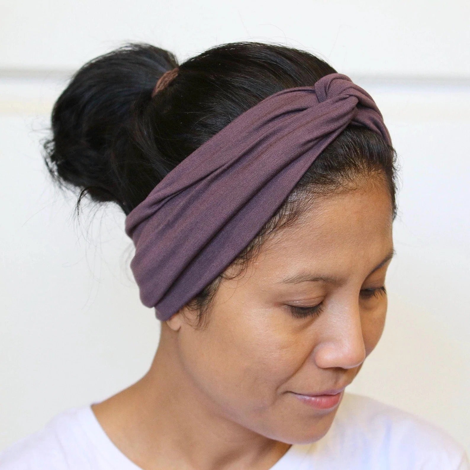Woman wearing a purple headband with a white background