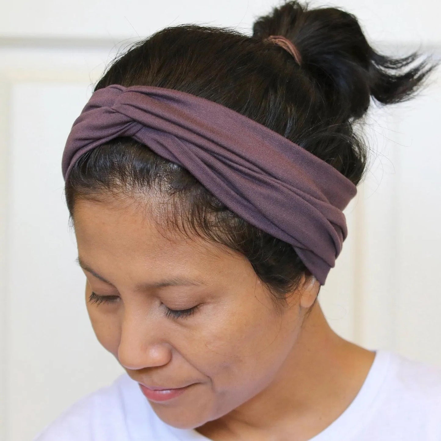 Woman wearing a purple headband with a white background