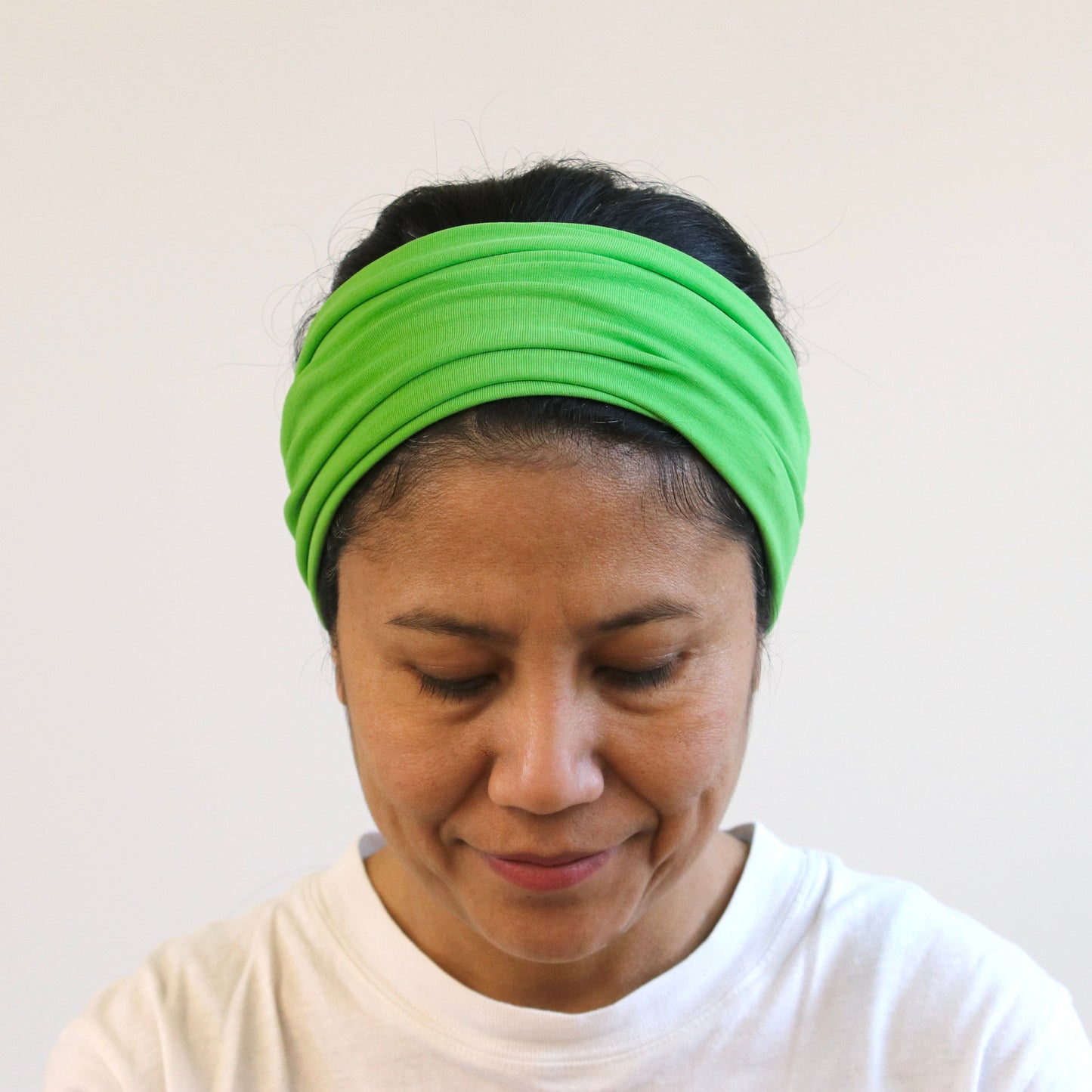 Person wearing a green headband against a white background