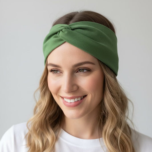 Woman wearing a green headband against a plain background