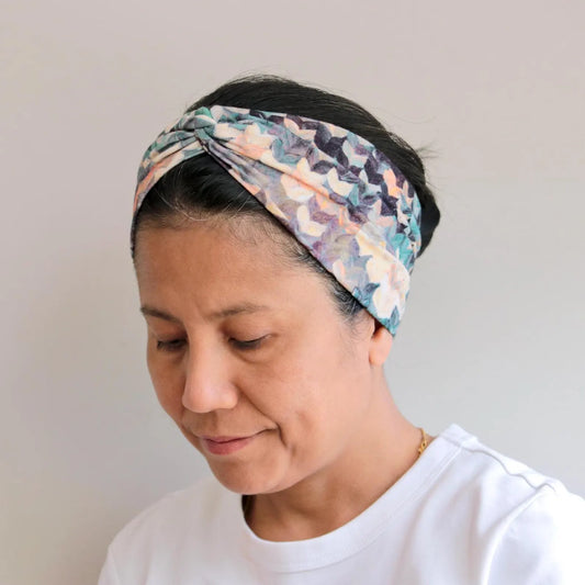 Woman wearing a patterned headband against a plain background