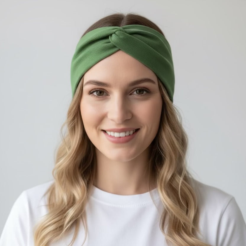 Woman wearing a green headband against a plain background
