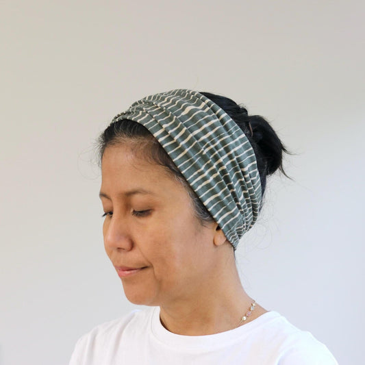 Woman wearing a patterned headband against a plain background