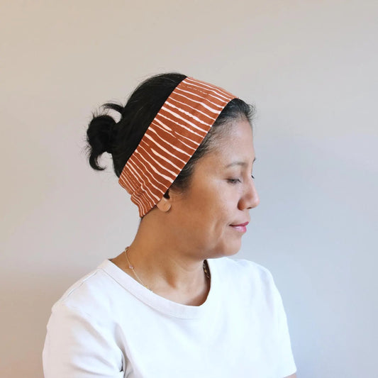 Woman wearing a striped headband with a plain background