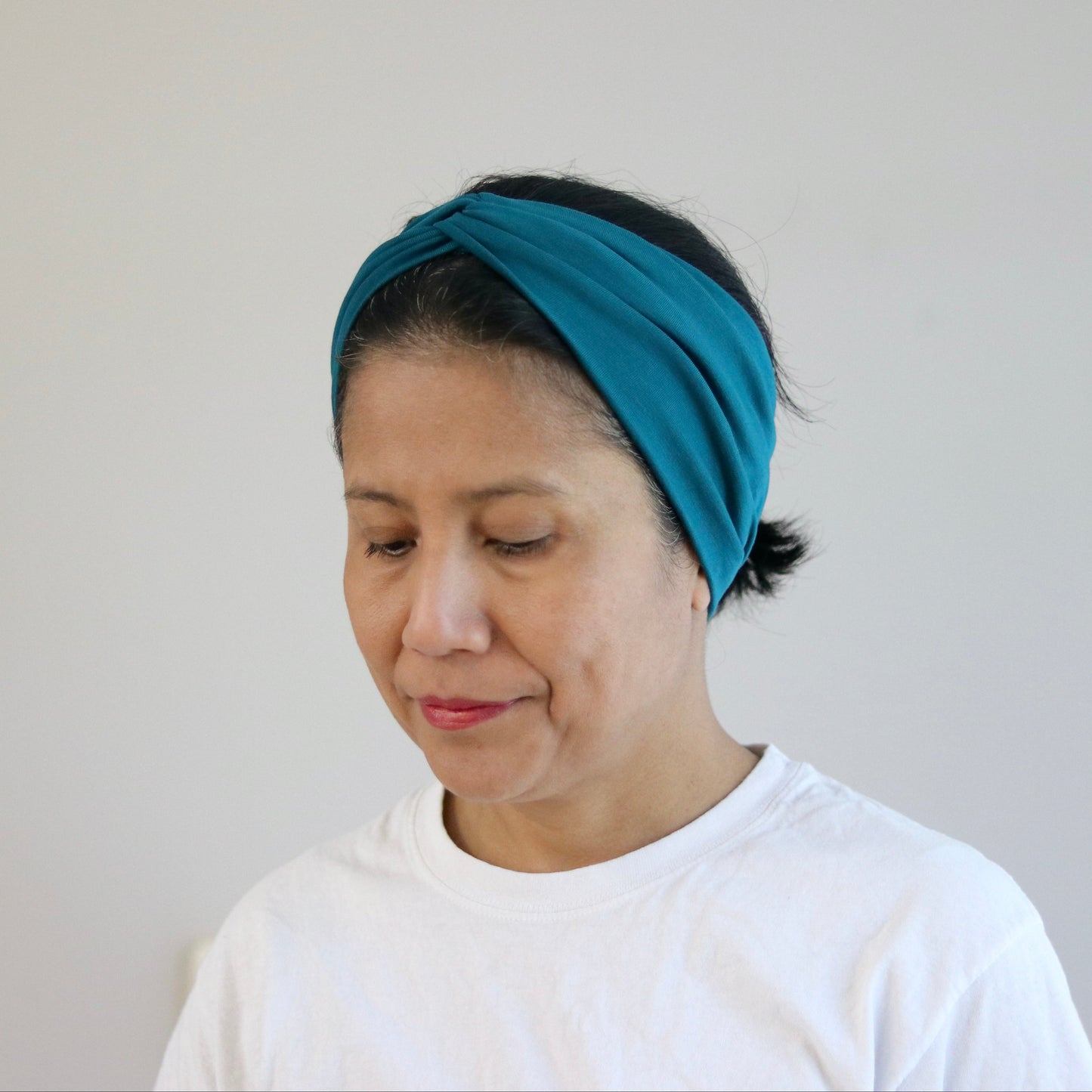 Person wearing a blue headband against a plain background