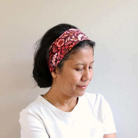 Woman wearing a red burgundy headband against a plain background