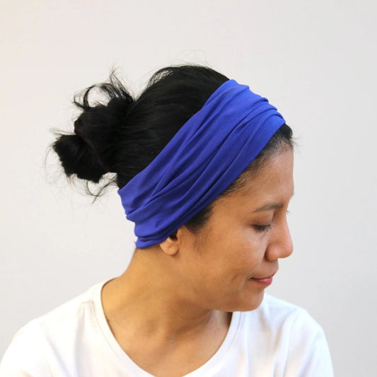 Woman wearing a blue headband against a white background