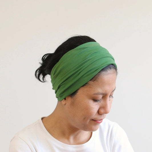 Woman wearing a green headband against a white background
