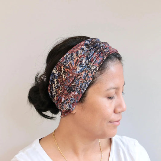 Woman wearing a patterned headband against a plain background