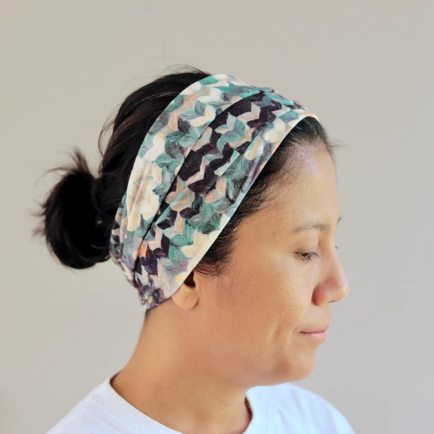 Woman wearing a patterned headband against a plain background