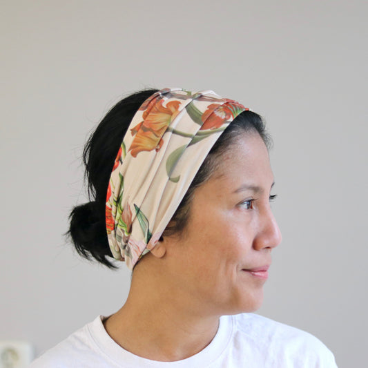 Woman wearing a floral headband against a plain background