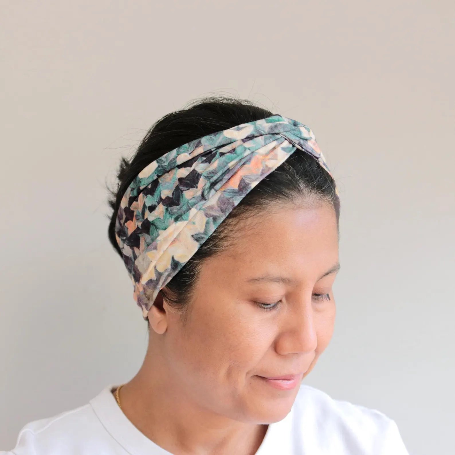 Woman wearing a patterned headband against a plain background