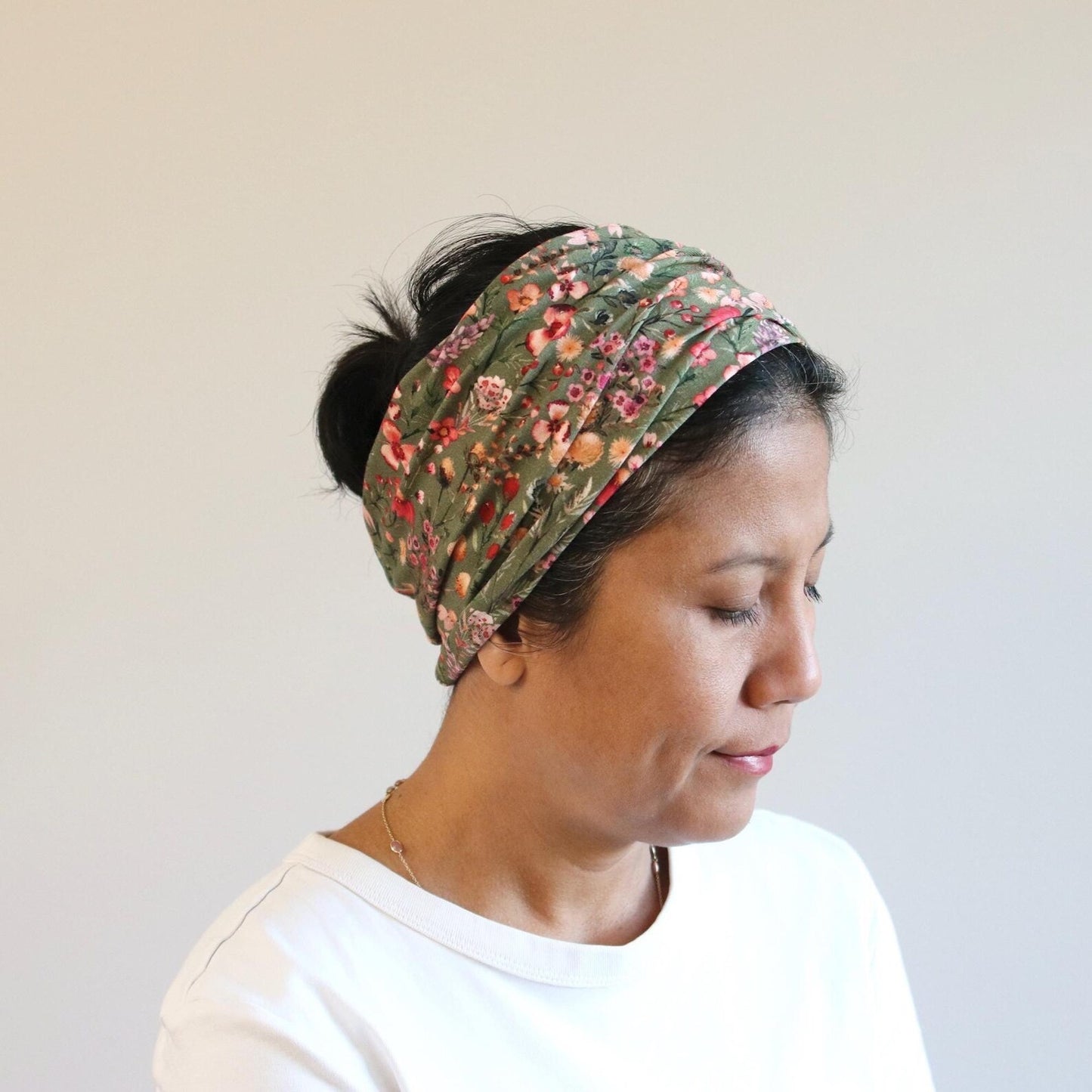 Woman wearing a floral headband against a plain background