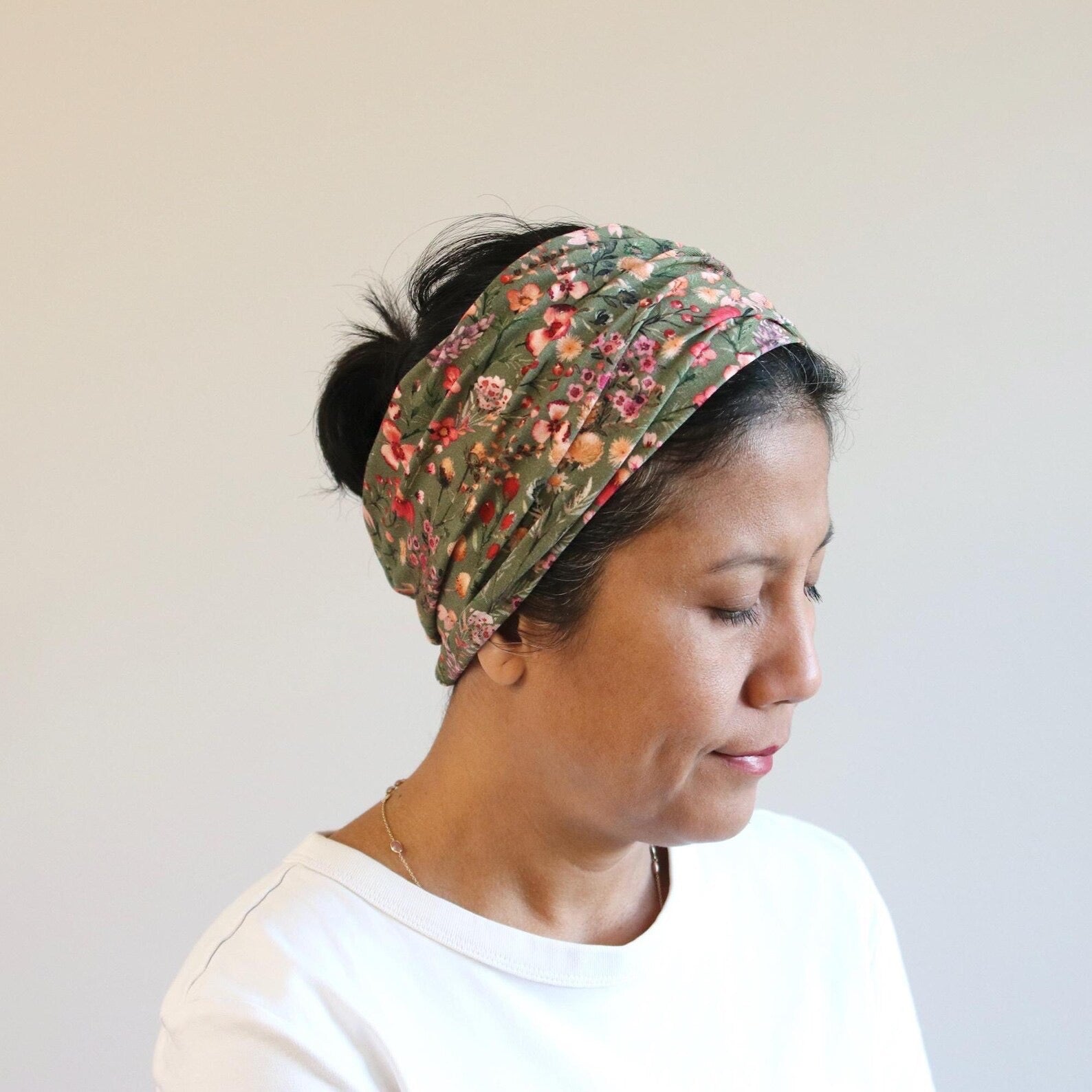 Woman wearing a floral headband against a plain background