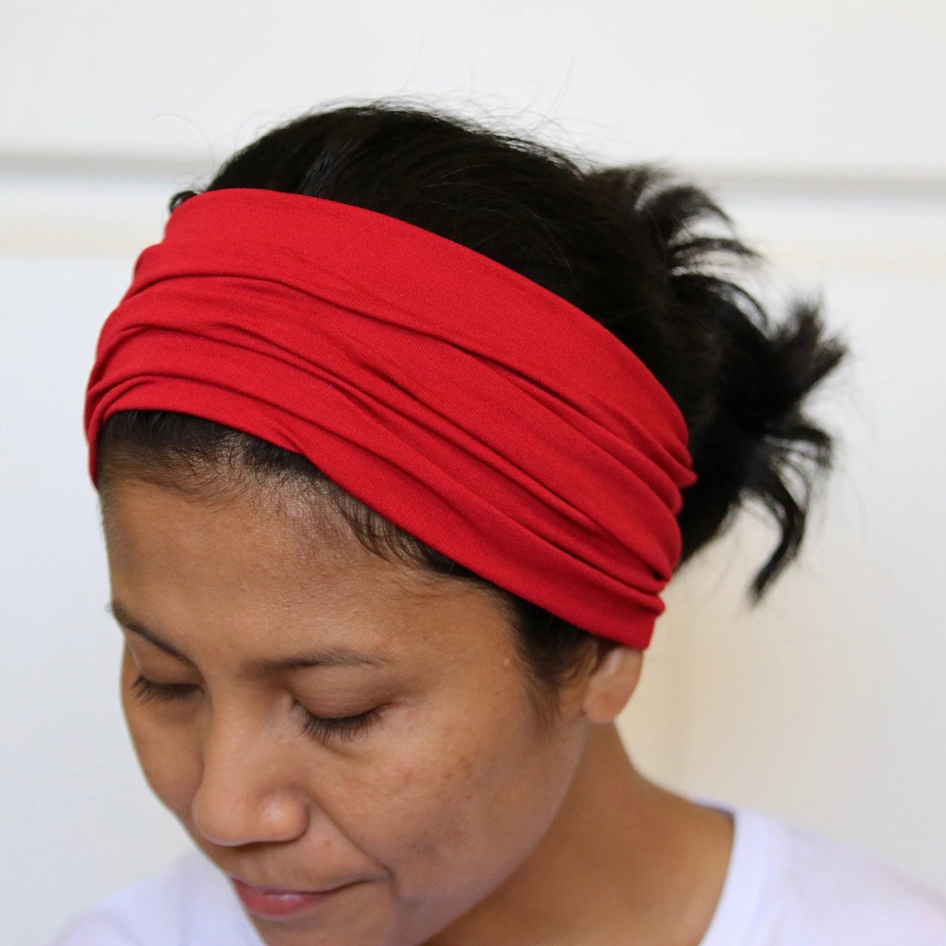 Person wearing a red headband against a plain background