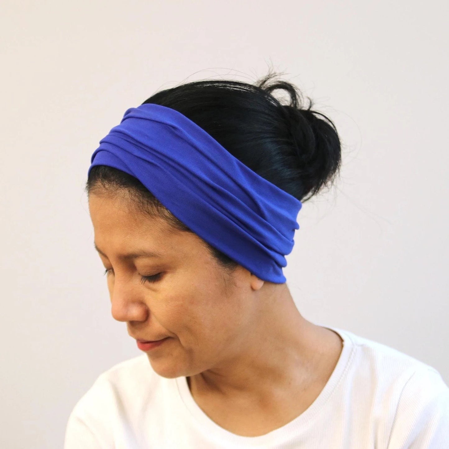 Person wearing a blue headband against a plain background