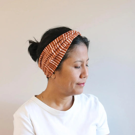 Woman wearing a patterned headband against a plain background