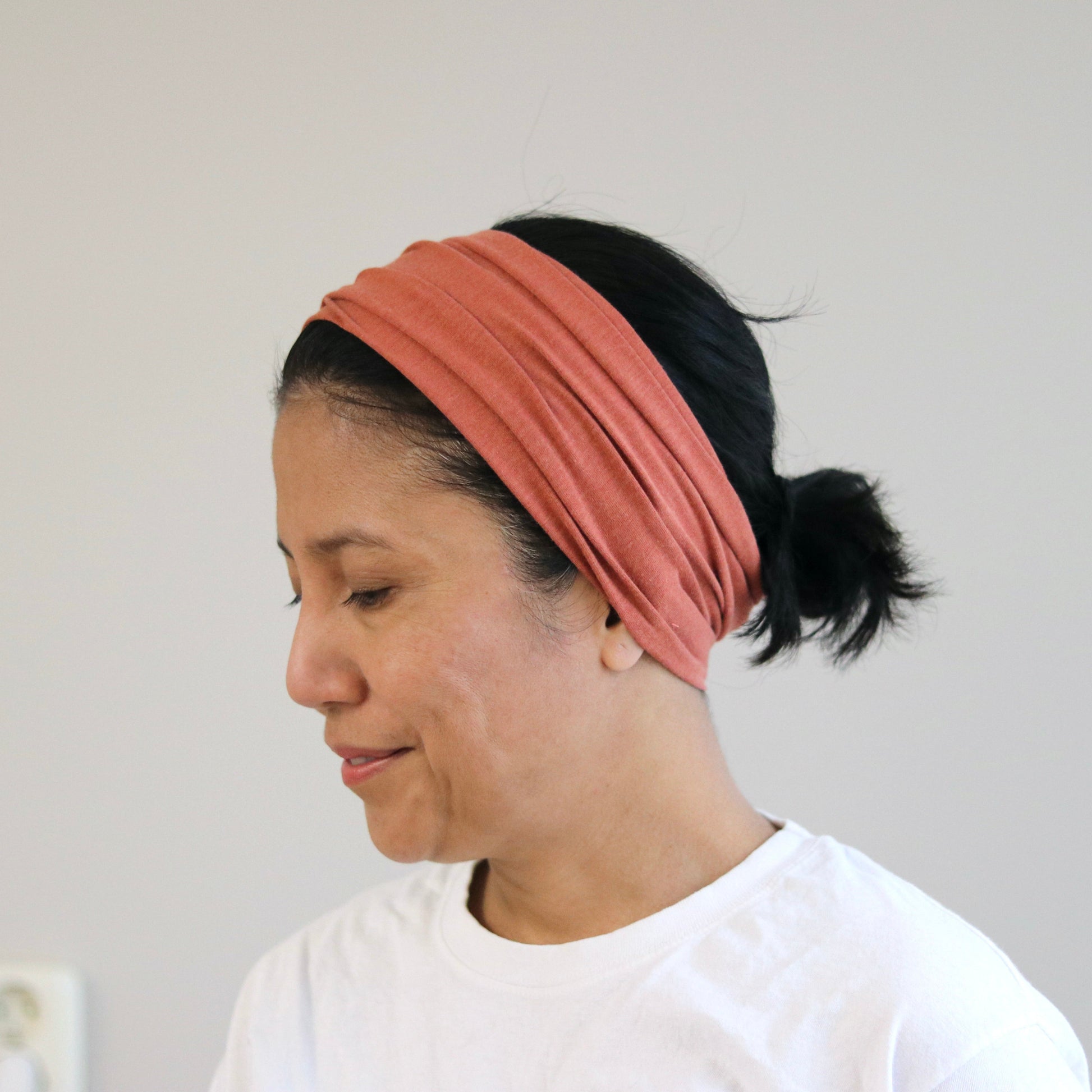 Woman wearing a terra headband against a plain background