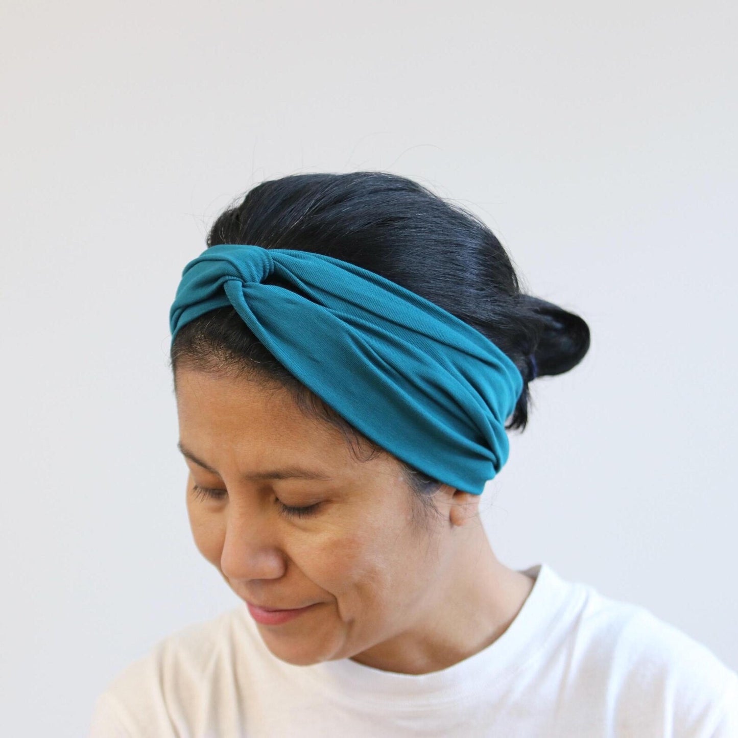 Woman wearing a blue headband against a white background