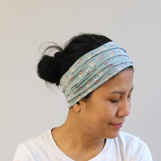 Woman wearing a patterned headband against a plain background
