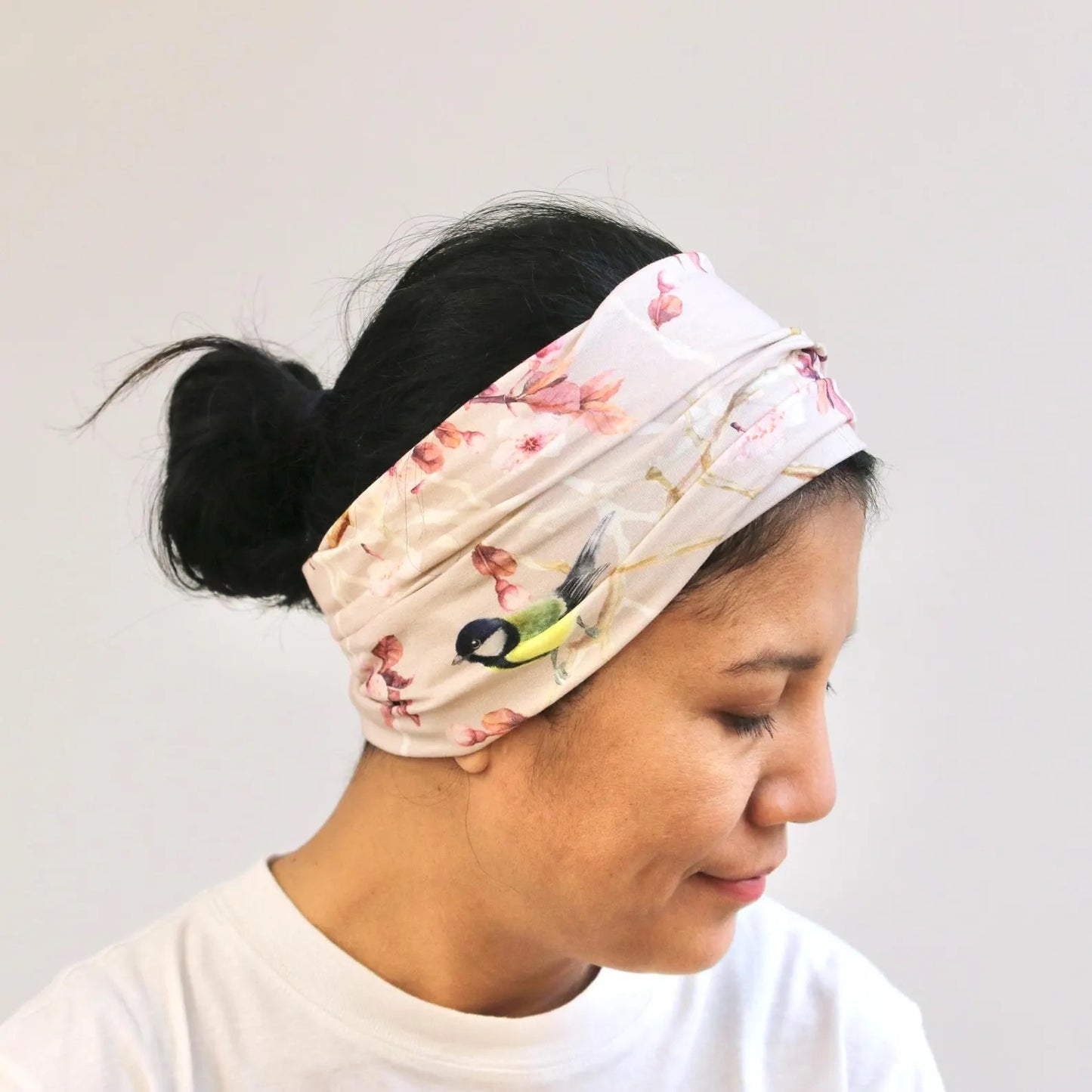 Woman wearing a floral headband with a plain background
