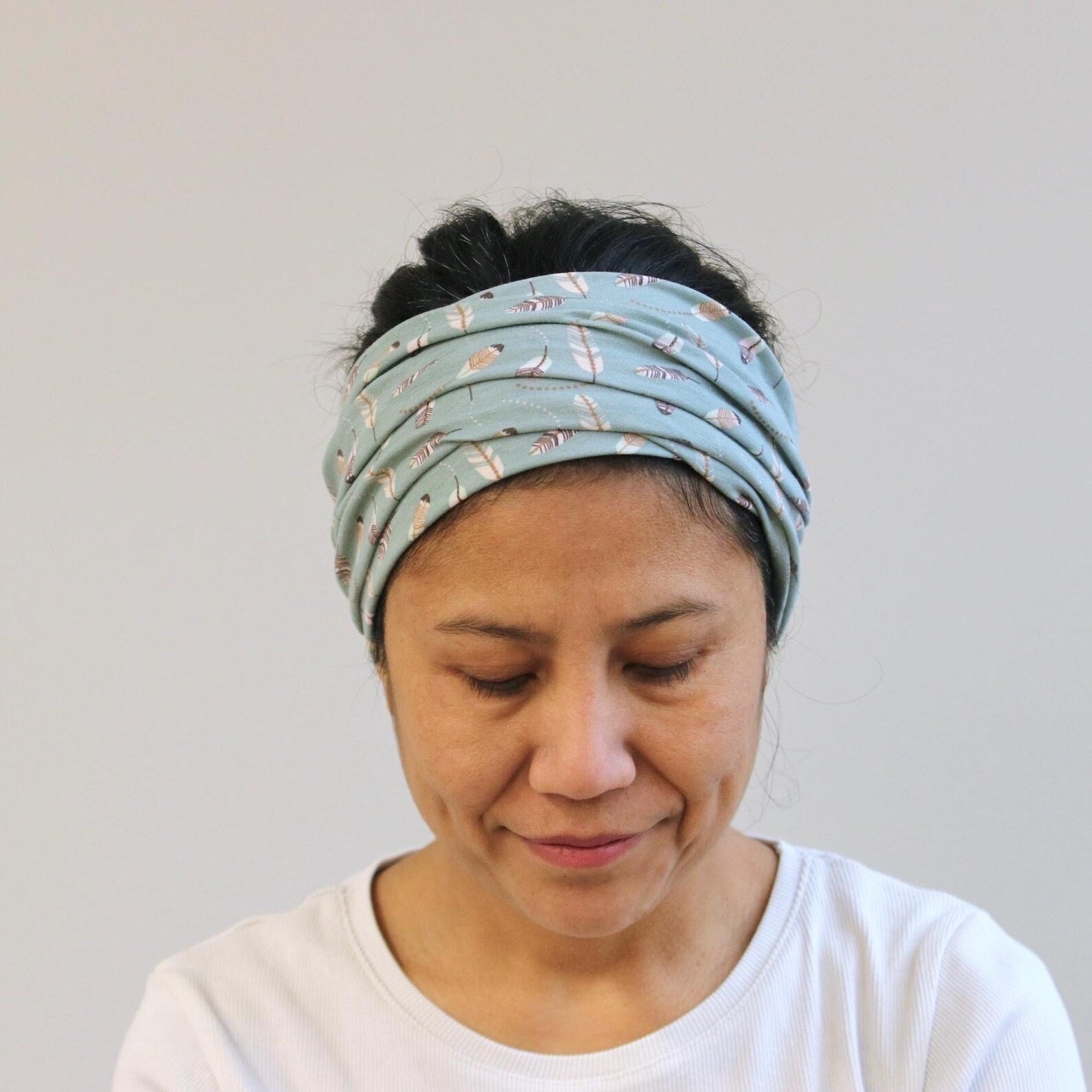 Woman wearing a patterned headband against a plain background
