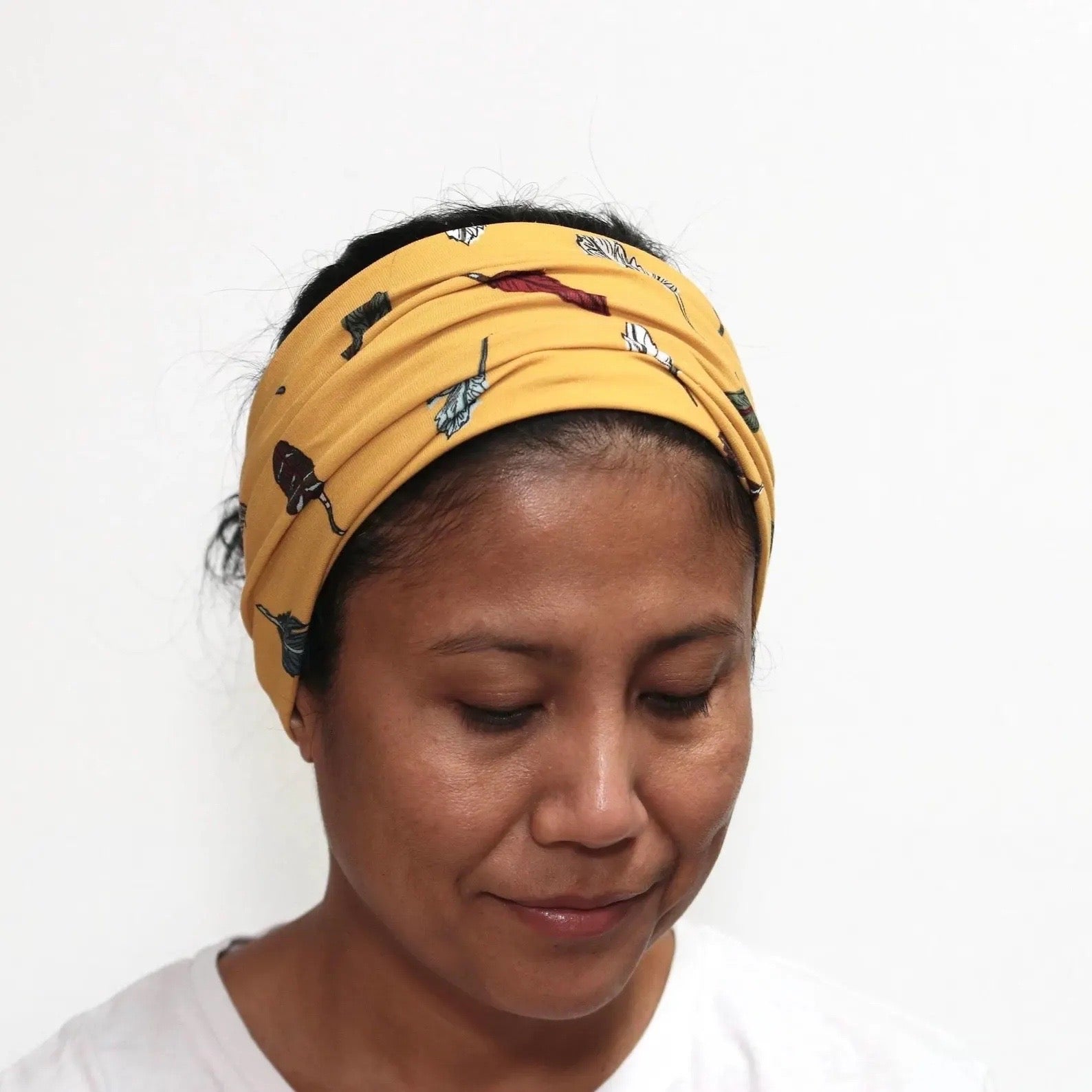 Woman wearing a yellow headband with animal prints on a white background
